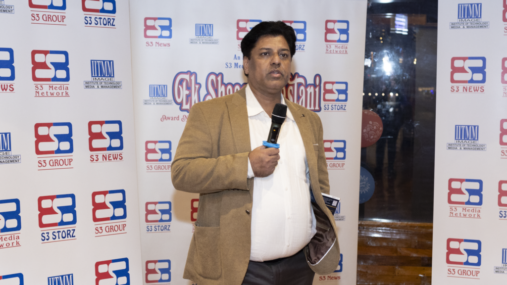 Mujib Rehmani holding microphone and saying something while hosting a fashion show event.